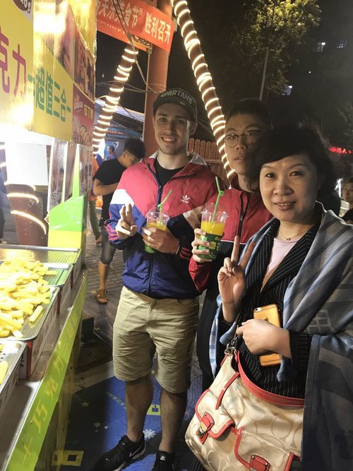 three people with drinks from food stand in China