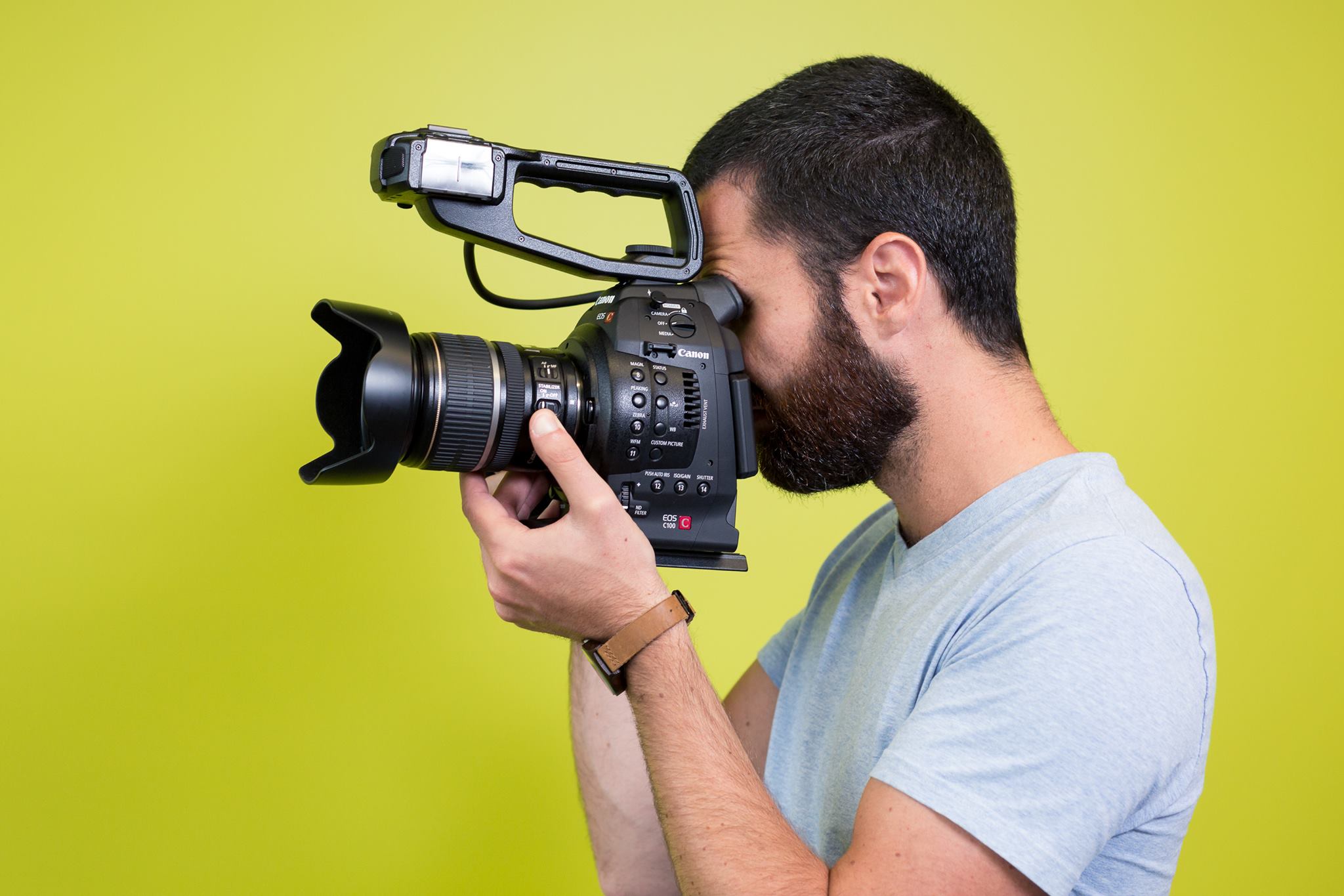 man holding camera in front of green background