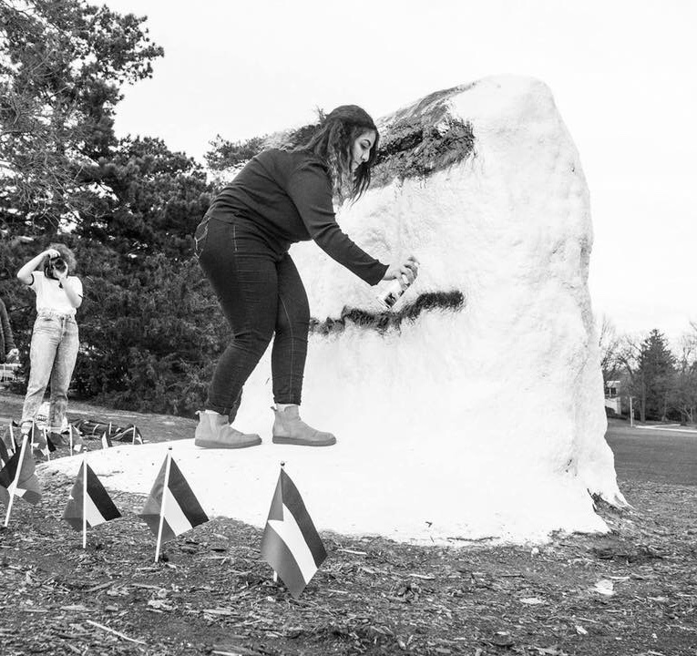 woman spray painting the Rock