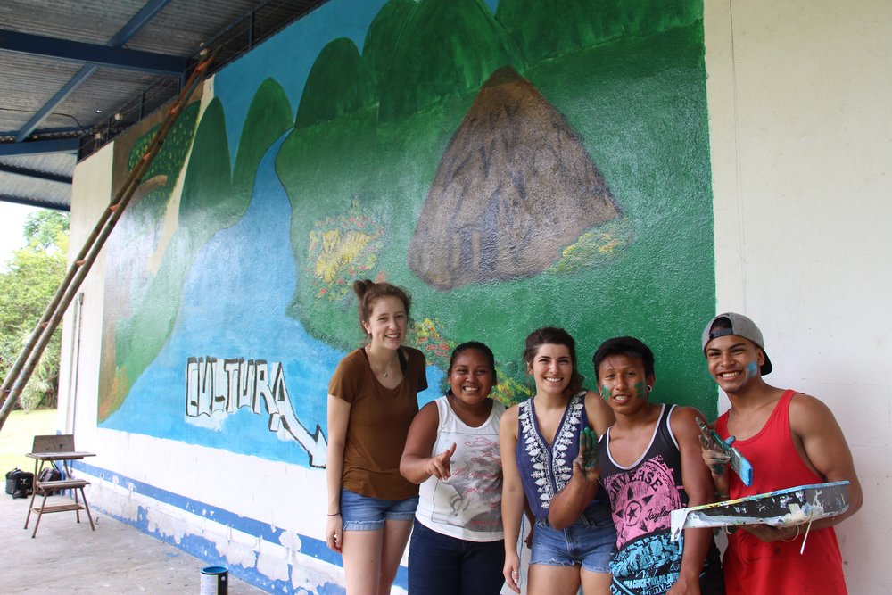 group of people in front of mural