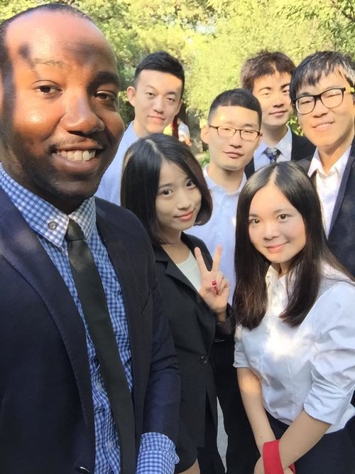 man smiling with Chinese classmates