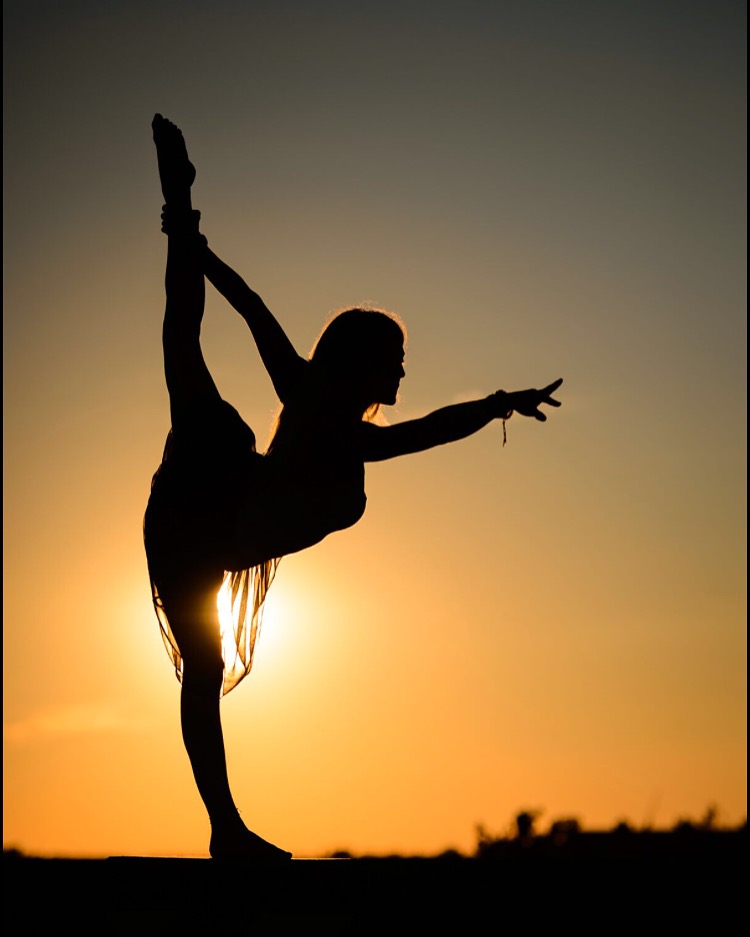 woman doing yoga at sunset