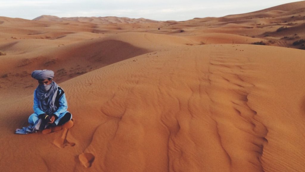 person sitting in desert