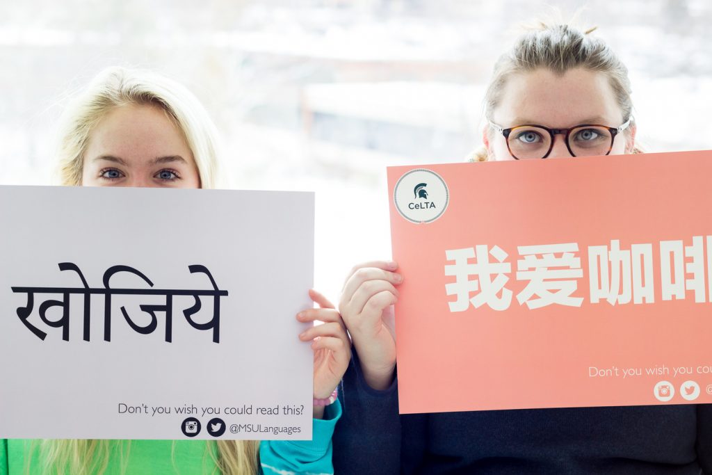 Two women hold up signs in foreign languages. Underneath, in English, it reads "Don't you wish you could read this?".